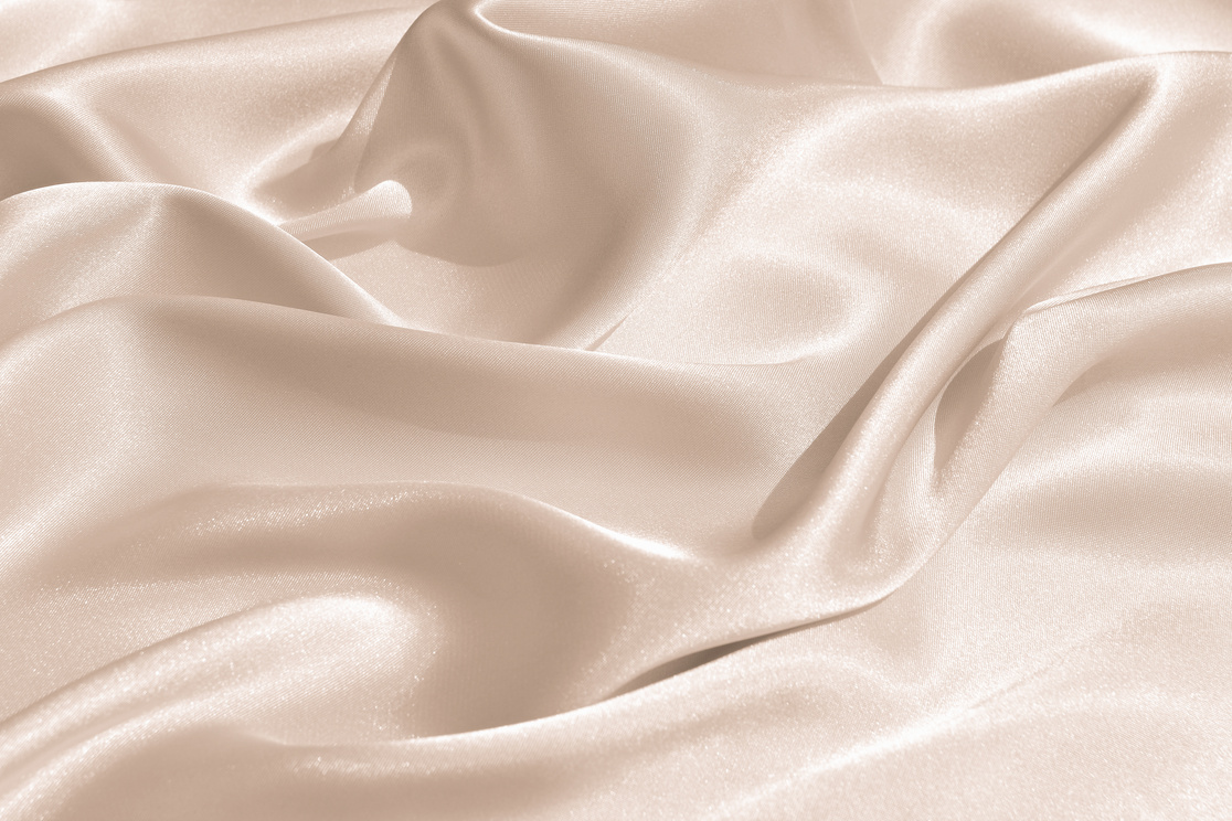 The texture of the satin fabric of beige color